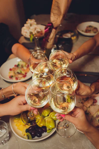 Крупним планом знімок групи людей, що чіпляються за келихи з вином або шампанським перед фоном боке. літні люди руки . — стокове фото