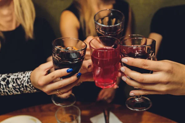 ボケの背景の前でワインやシャンパンでグラスをクリックしている人々のグループのショットを閉じます。高齢者の手. — ストック写真