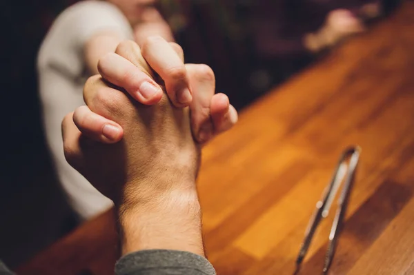 Fechar masculino e feminino de mãos dadas sobre a mesa. — Fotografia de Stock