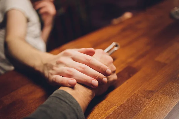 Close-up man en vrouw het houden van handen over tafel. — Stockfoto