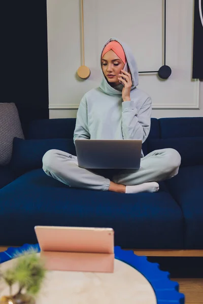 Beautiful Muslim middle-aged woman with laptop at home.