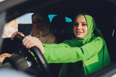 Arabayla seyahat eden Arap genç kadın çift.