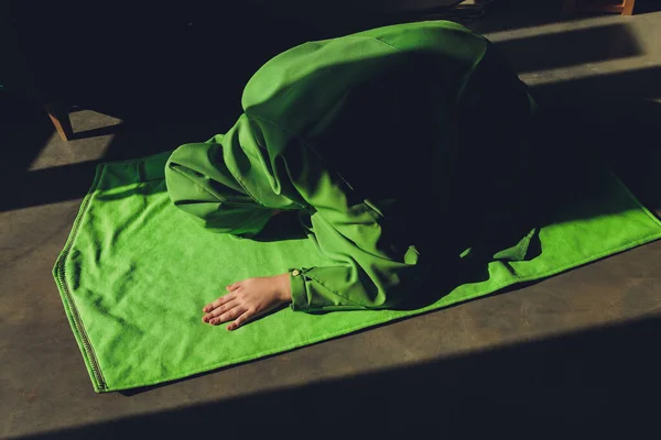 Mulher muçulmana em hijab orando no tapete dentro de casa. — Fotografia de Stock