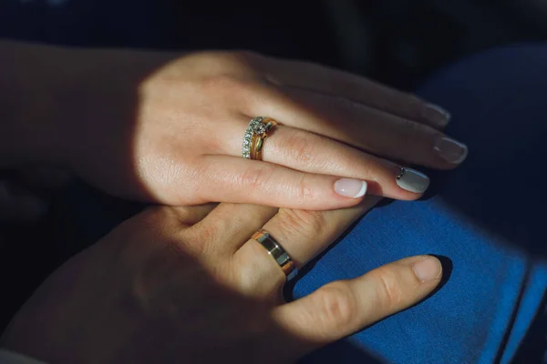 Close-up uitzicht op pasgetrouwde handen houden kleurrijke bruiloft boeket. Bruid en bruidegom dragen trouwringen. Buiten achtergrond. Wedding day concept. — Stockfoto