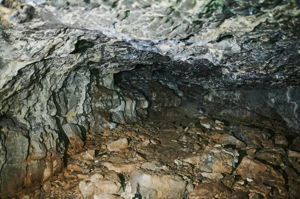 Caverna de pedra dentro. vista perto da entrada. — Fotografia de Stock
