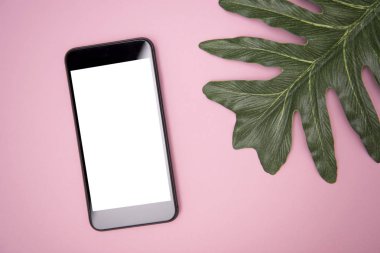 hareket eden telefon ile boş beyaz ekran ve tropikal yaprak pembe tablo. mockup reklam.