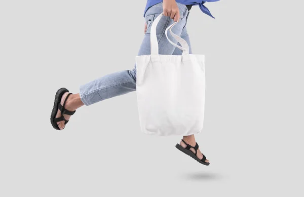 Kız çantası kanvas kumaş mockup boş şablon gri arka plan üzerinde izole için tutuyor. 