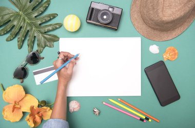 Mockup siyah kağıt düz lay ve çevresinde seyahat aksesuarları. Üstten görünüm seyahat veya tatil kavramı. Yaz arka plan.