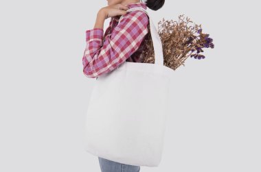 Kız çantası kanvas kumaş mockup boş şablon gri arka plan üzerinde izole için çiçek ile düzenliyor. 