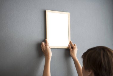 El Holding boş beyaz fotoğraf çerçevesi asılı duvar tasarım Mockup şablonu için. 