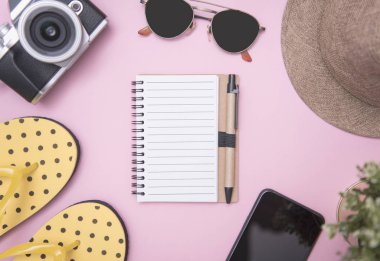 Mockup defter ve seyahat aksesuarları çevresinde. Üstten görünüm seyahat veya tatil kavramı. Yaz arka plan.