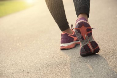 Genç atlet kadınlar Road günbatımı arka plan ile koşu. Sağlıklı yaşam konsepti.