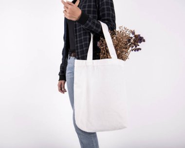 Kız çantası kanvas kumaş mockup boş şablon gri arka plan üzerinde izole için çiçek ile düzenliyor. 