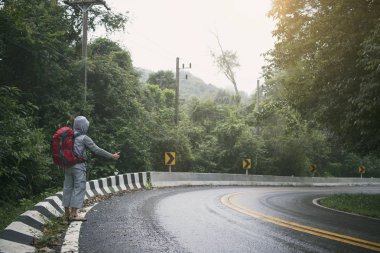 Dağ tatil gezisi sırasında gün batımında yolu üzerinde seyahat adam otostopçu. kavramı macera ve otostop.