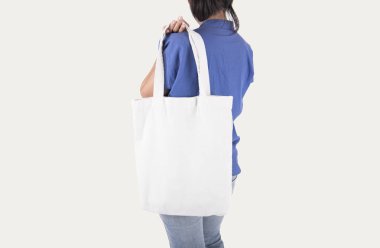 Kız çantası kanvas kumaş mockup boş şablon gri arka plan üzerinde izole için tutuyor. 