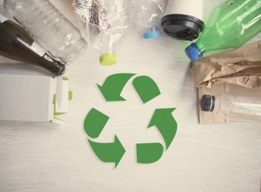 geri dönüşüm sembolü ve plastik, kağıt, cam ahşap masa arka plan üstten görünüm üzerinde. Eko ve dünya kavramı kaydetmek.