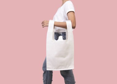 Kız çantası kanvas kumaş pembe arka plan izole mockup boş şablon için tutuyor. 