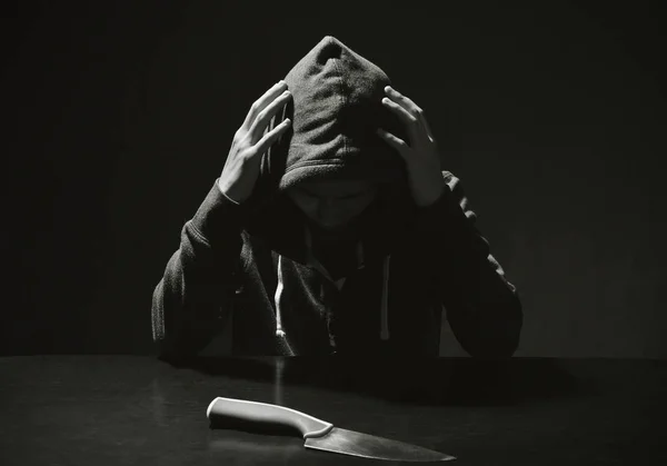 Mysterious man hooded and knife in interrogation room. committed a crime concept.