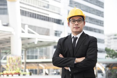 Genç Asyalı mühendis stand ve silah ile poz açık şantiye geçti.