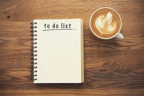 Kahve fincanı ve defter ile yukarıdan, planlayıcısı ve denetim listesi kavramı rustik masa üzerinde listelemek için.