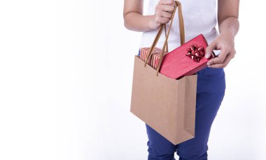 Alışveriş kağıt çanta ve hediye kutusu beyaz arka planda tutan el. Noel alışveriş ve mutlu yeni yıl kavramı.