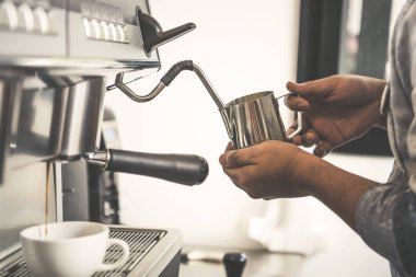 Espresso kahve makinesi ayıklama kullanarak Barista vurdu ve kafede Buhar süt.