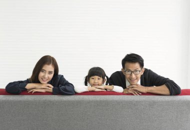 Aile Asya Anne ve baba ile kızı mutlu togetheron kanepe oturma odası evde.