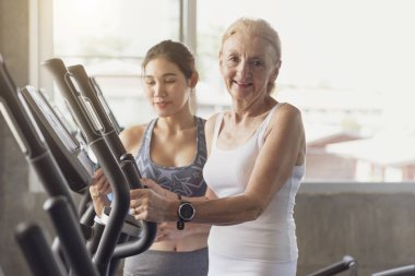 Eğirme kiralama fitness salonunda egzersiz kadın kıdemli eğitmen. Yaşlı sağlıklı yaşam konsepti.