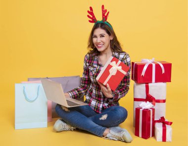 mevcut online pazarlama üzerinde sarı arka plan izole alışveriş için bilgisayar kullanan kadın. Siber Pazartesi ve Noel yılbaşı konsepti.
