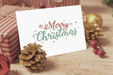 Ahşap masa dekorasyonu ile kağıt kartı tasarım mockup tebrik Noel tatili.