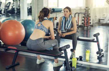 Genç Asyalı sportif kadın fitness jimnastik salonu iş sonra havlu ile oturmuş yorgun.