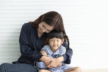 Asya Anne ve kızı birlikte evde oturma sarılma. kavram mutlu anneler günü.