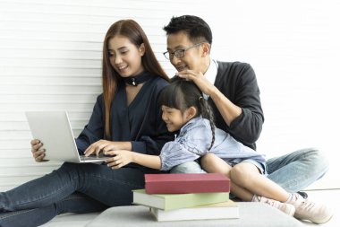 Aile Asya Anne ve baba ile kızı birlikte oturma içinde evde mutlu. bilgisayar oynuyorlar.