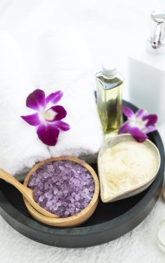 Spa aksesuarları kokulu mum, orkide çiçek, tuz fırçalama ve havlu.