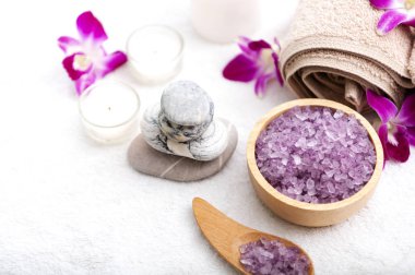 Spa aksesuarları kokulu mum, orkide çiçek, tuz fırçalama ve havlu.