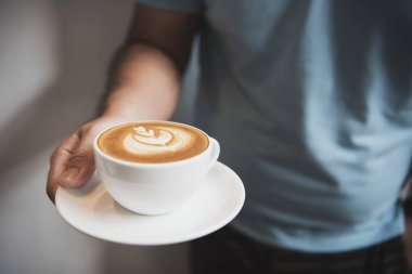 Köpüklü köpüklü, kahve Kupası üstten görünüm cafe latte veya kapuçino tutan el.