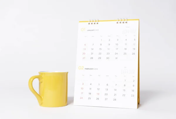 灰色背景上的空白黄色帽模型和纸螺旋日历年2019 — 图库照片