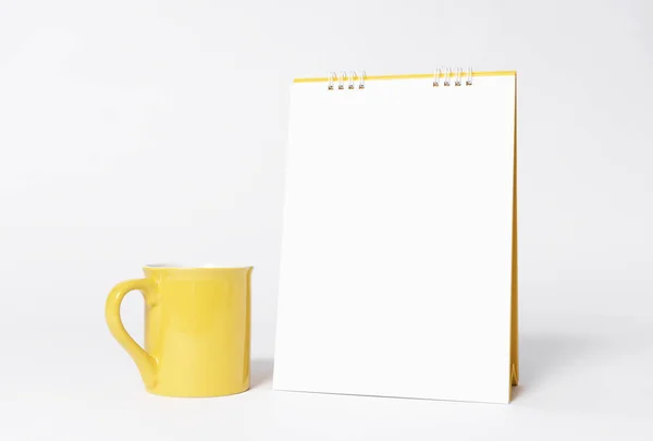 Calendrier spirale en papier blanc et tasse jaune pour gabarit de maquette — Photo