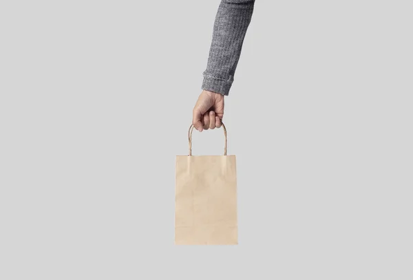 Χέρι που κρατά το κενό λευκό χαρτί τσάντα για mockup πρότυπο — Φωτογραφία Αρχείου