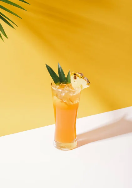 Iced pineapple punch cocktail in glass on orange background. — Stock Photo, Image