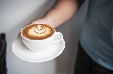 Köpük köpük, kahve fincanı ile el tutma latte veya Cappuccino 
