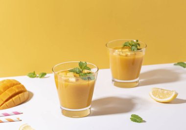 Renk arka planda taze mango smoothie ve olgun mango dilim. 