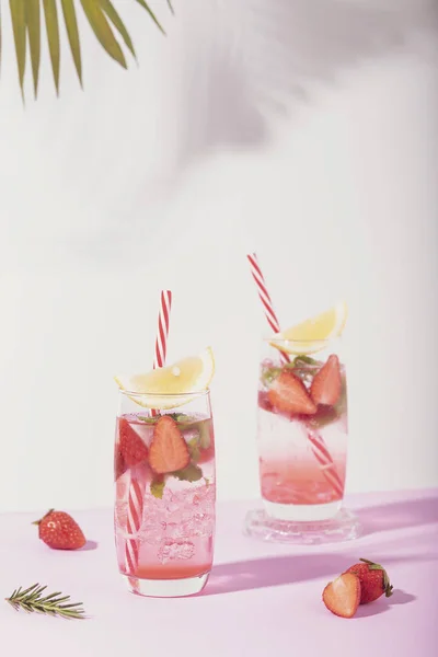 Крижаний полуничний коктейль у склянці з лимоном на білому — стокове фото