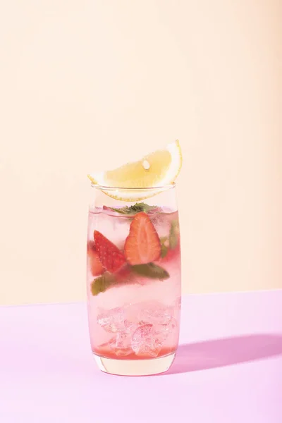 Коктейль со льдом и клубничным пуншем в стакане с лимоном — стоковое фото