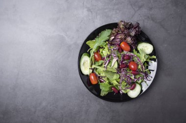 Masa arka plan üzerinde tabakta taze sağlıklı sebze salatası.