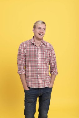 Gül genç adam ayakta kırmızı ekose gömlek giyiyor 