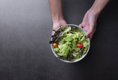 Masa arka plan üzerinde tabakta taze sağlıklı sebze salatası