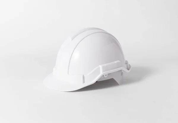 Белый пластмассовый защитный шлем для инженера на сером фоне . — стоковое фото