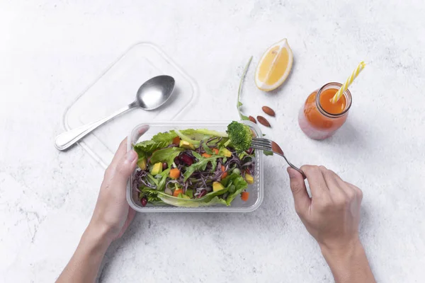Mano tenendo fresco scatola sana dieta pranzo con insalata di verdure su sfondo tavolo . — Foto Stock