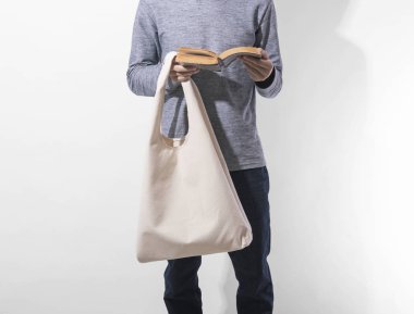 Adam beyaz arka plan üzerinde mockup boş şablon için çanta tuval kumaş tutuyor. küresel ısınma kavramı.